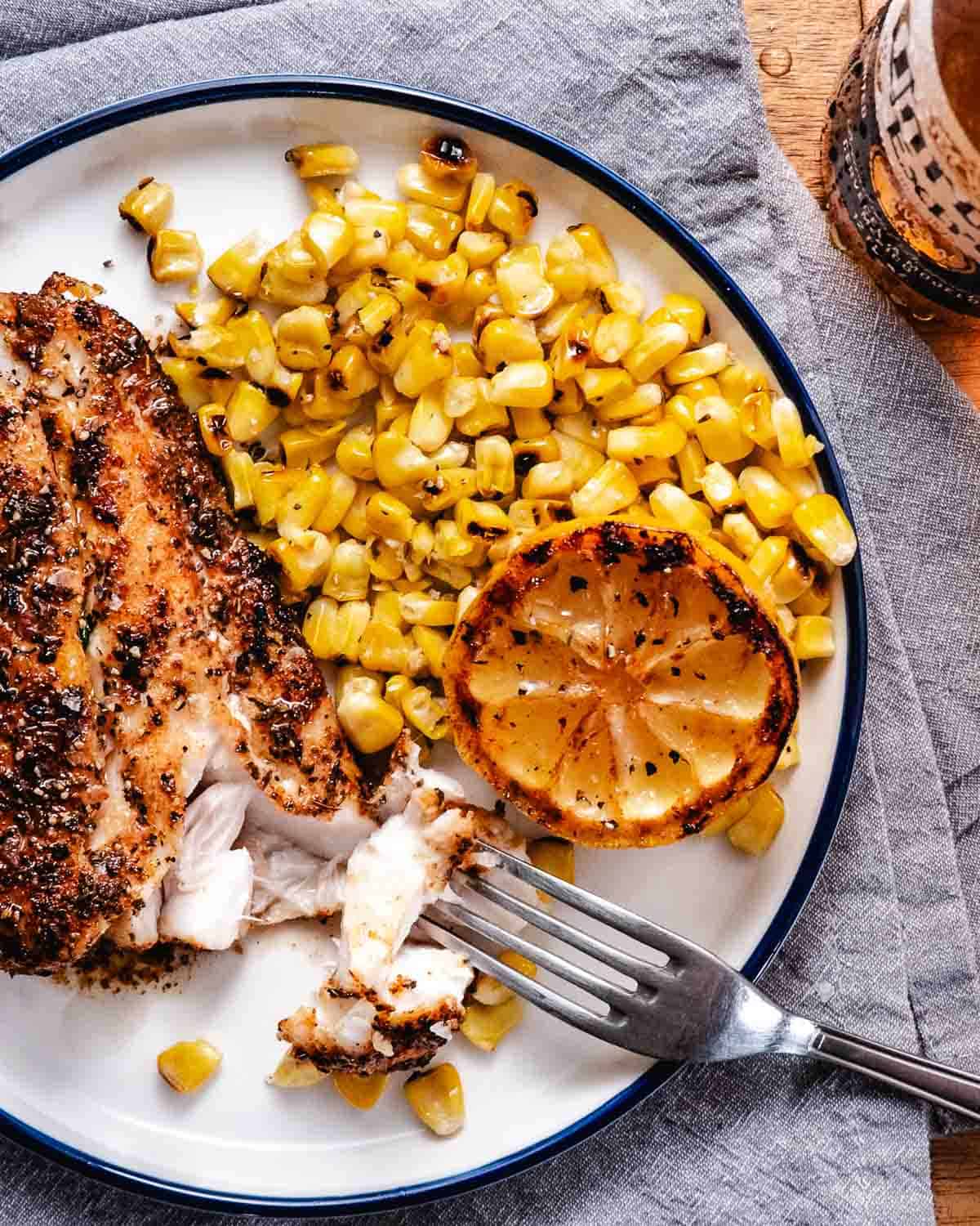 Grilled red snapper with corn and a caramelized lemon wedge