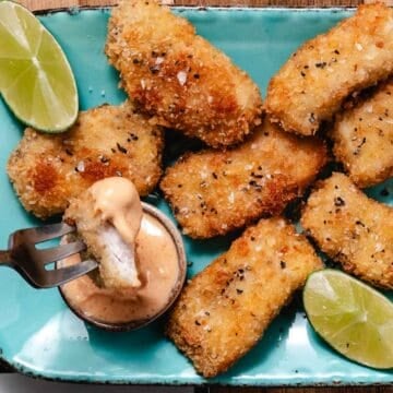 Crispy mahi mahi bite dipped in creamy Yum Yum Sauce with lime wedges.