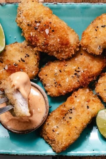 Crispy mahi mahi bite dipped in creamy Yum Yum Sauce with lime wedges.