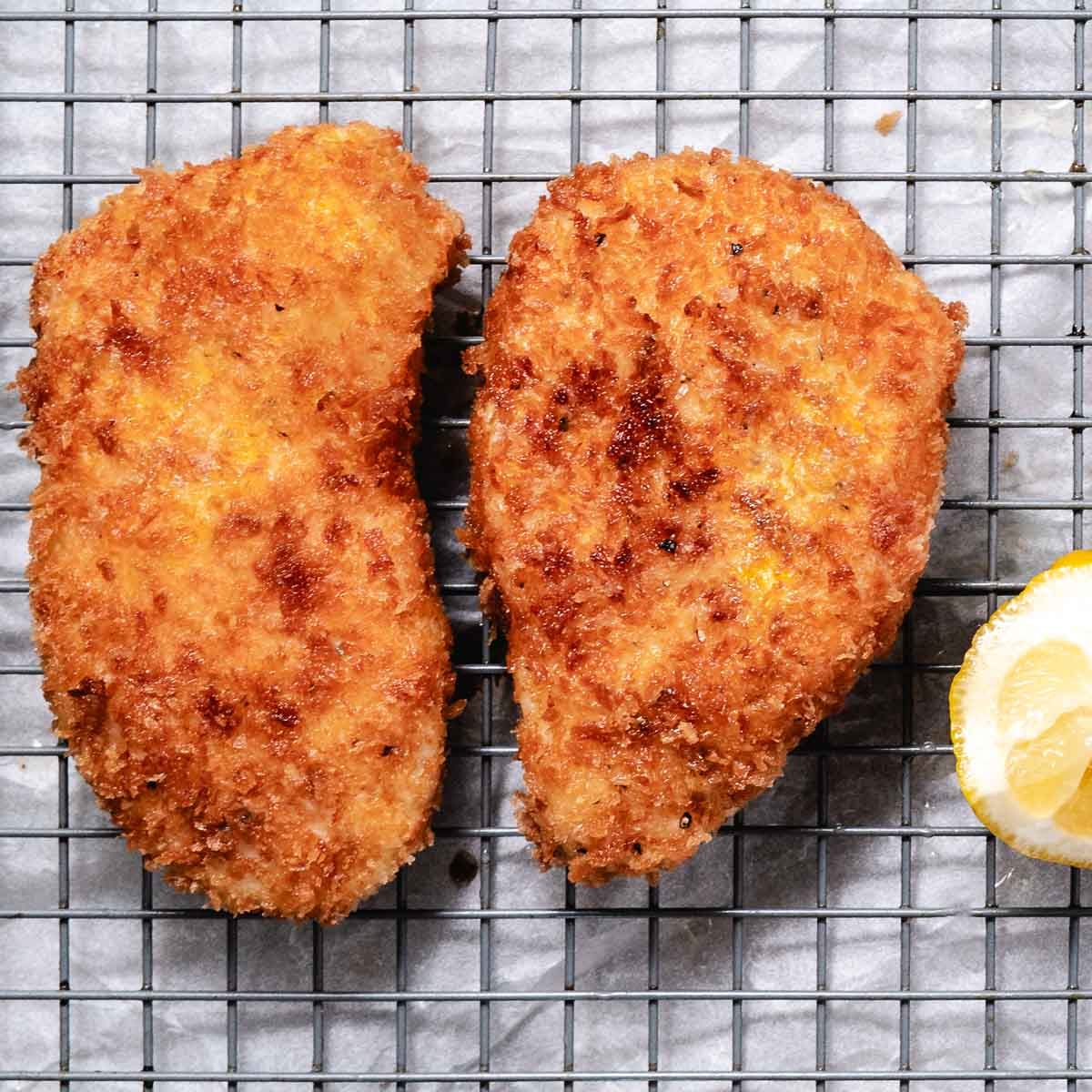 Fried Halibut fillets with a lemon wedge.