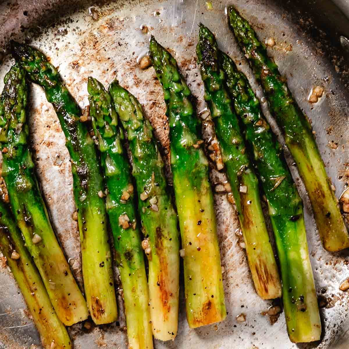 Thick asparagus sautéed in a skillet until browned in spots.