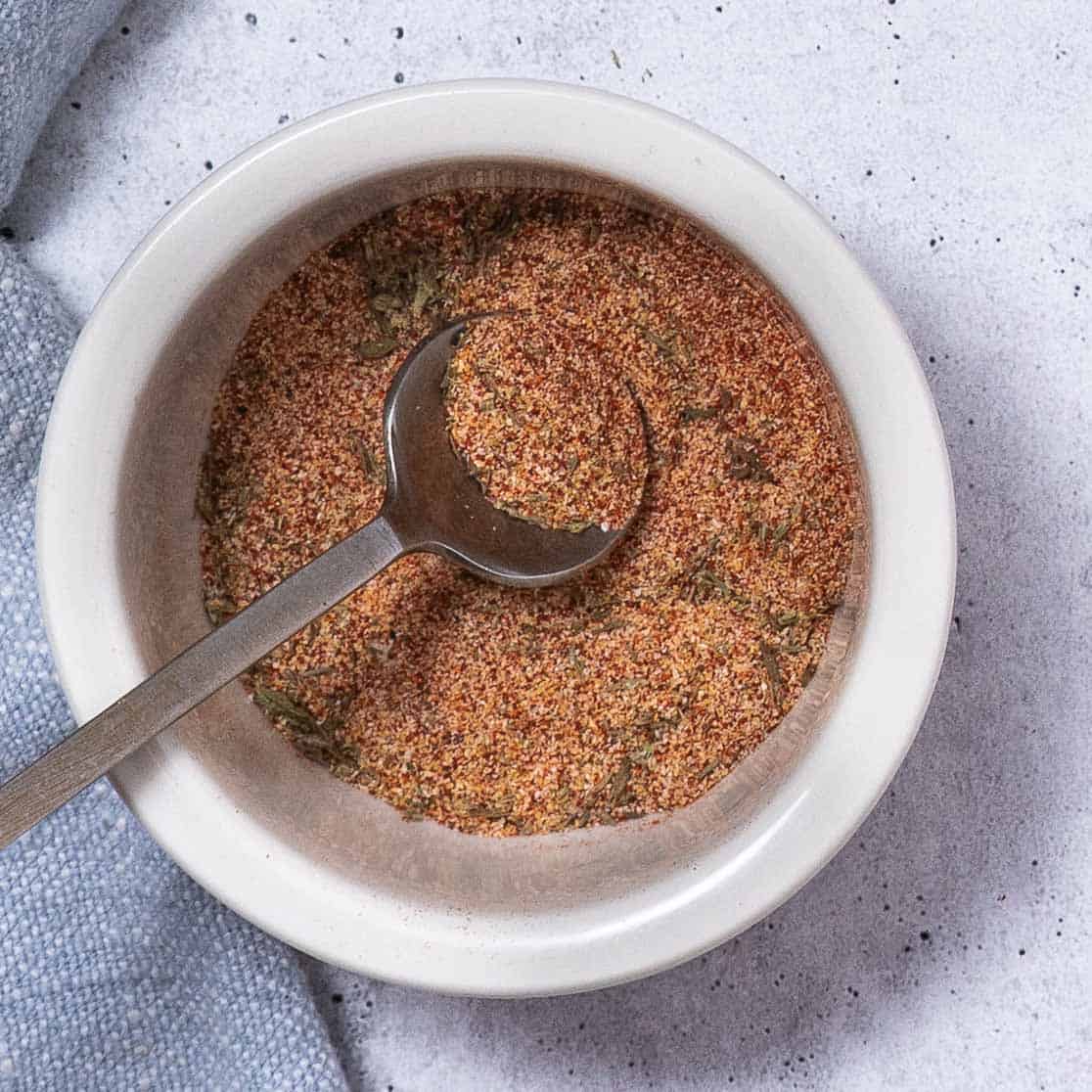 Paprika, thyme, garlic powder, onion powder, salt, and pepper mixed in a bowl.