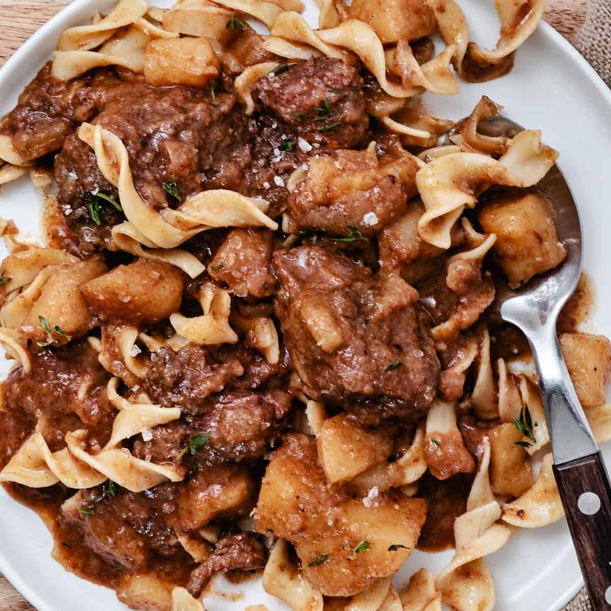 Plate of goulash over egg noodles.
