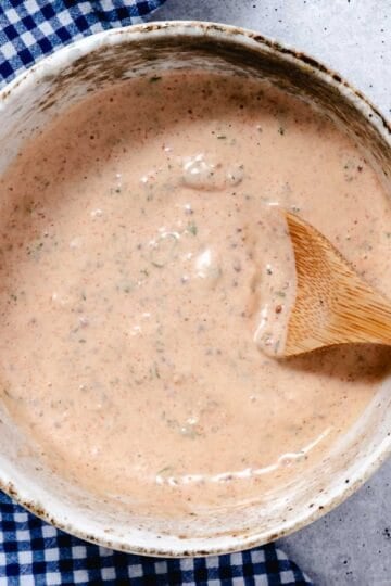 Bowl of remoulade sauce with a wooden spoon.