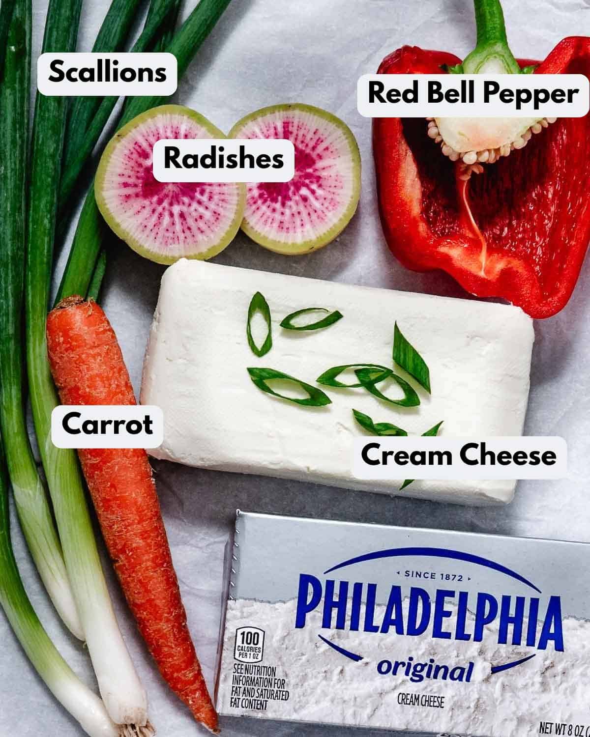 Vegetable cream cheese ingredients with cream cheese, scallions, carrot, red bell pepper, and watermelon radish.