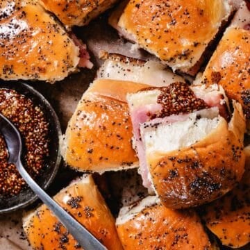 Honey baked ham and cheese sliders on Hawaiian rolls with a honey mustard poppy seed glaze.