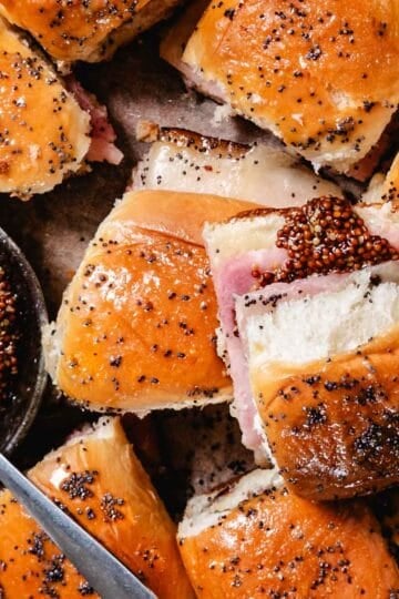 Honey baked ham and cheese sliders on Hawaiian rolls with a honey mustard poppy seed glaze.