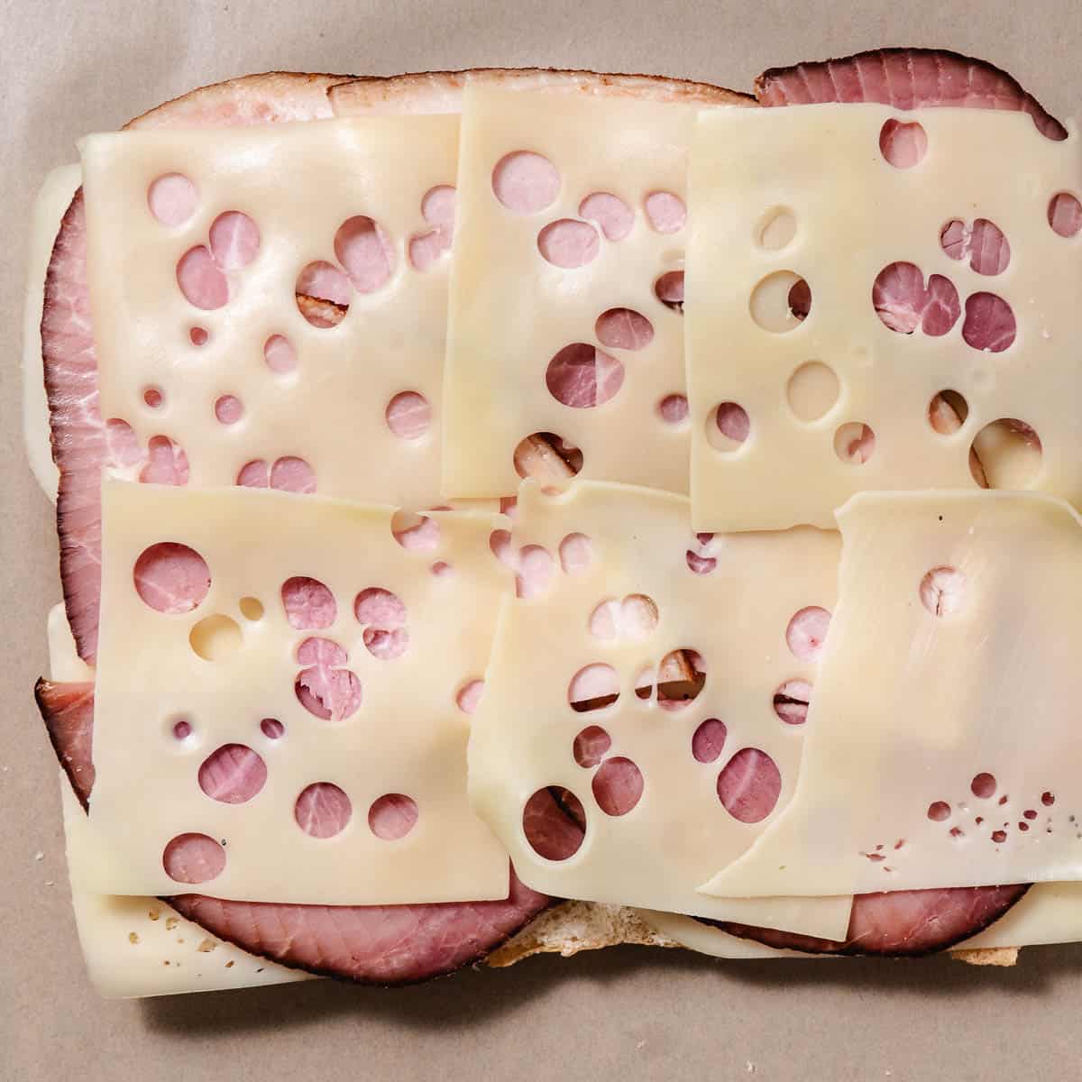 Swiss cheese and sliced ham layered on the bottom half of Hawaiian rolls.