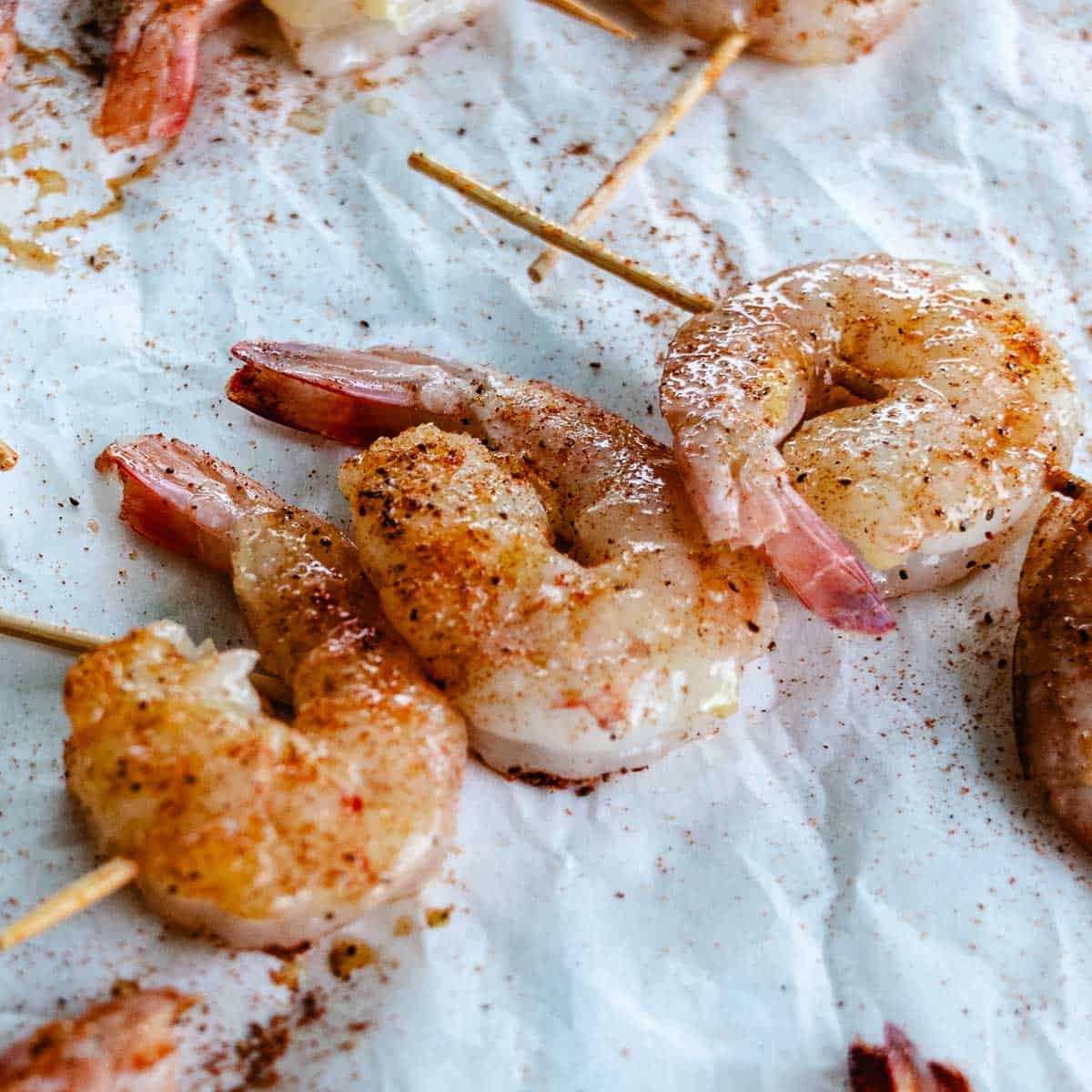 Raw shrimp on mini wooden skewers brushed with garlic, olive oil, and Old Bay seasoning.
