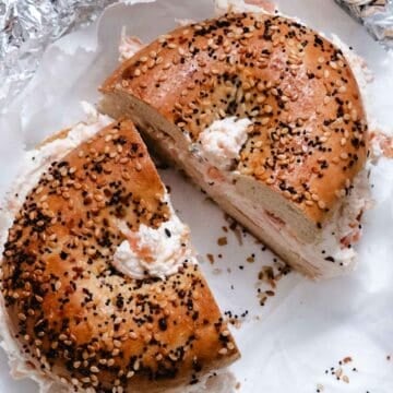 Smoked salmon cream cheese on an everything bagel cut into two halves.